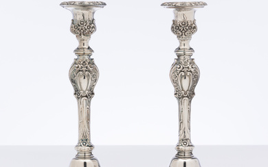 A pair of silverplate candlesticks with deeply moulded floral decoration,...