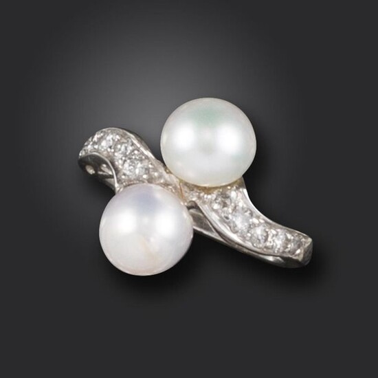 A pearl and diamond crossover ring, set with two pearls with round brilliant-cut diamonds to the shoulders in platinum, size I Accompanied by report number 01229 dated 9 October 2008 from The Gem & Pearl Lab, stating that the two button-shaped pearls...