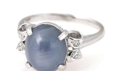 A sapphire and diamond ring set with a cabochon star sapphire weighing...