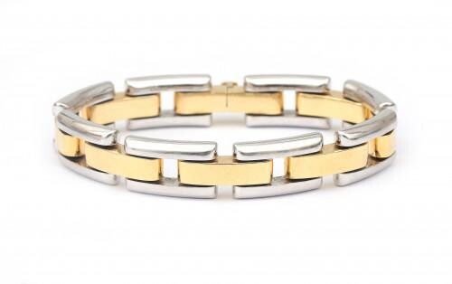 An 18 karat gold two tone link bracelet. Composed of puffy alternating links in white and yellow gold, to a tongue clasp. Gross weight: 39.36 g.