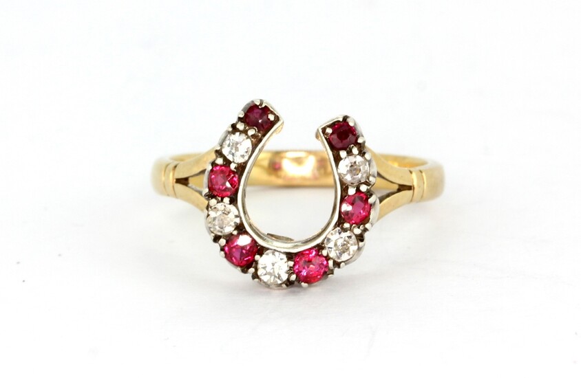 An antique yellow and white metal (tested minimum 9ct gold and silver) horseshoe shaped ring set with old cut diamonds and rubies, (O).