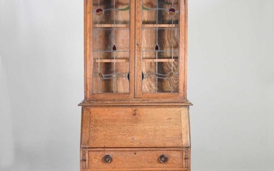 An early 20th century oak bureau bookcase, with stained leaded...