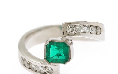 An emerald and diamond ring set with an emerald weighing app. 0.43 ct. flanked by ten diamonds, totalling app. 0.32 ct., mounted in 18k white gold. Size app. 50