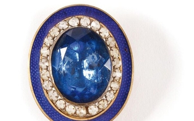 Oval gilt brooch decorated with a faceted blue stone and...