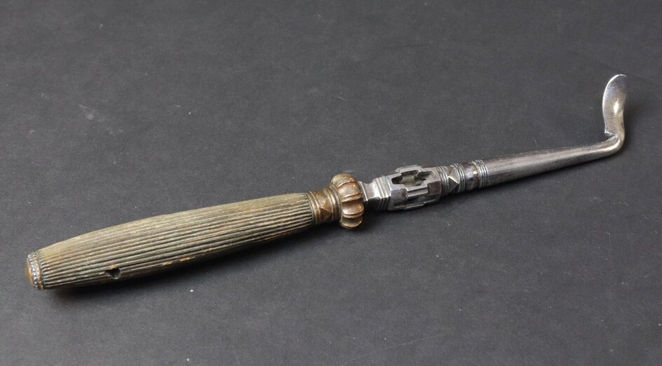 Surgical instrument in steel with a baluster shaped fitting with openwork in its centre holding a free ball. Brass ferrule and bolster, grooved horn handle. 18TH CENTURY. Length 17,8 cm. Minor accident to the horn of the handle