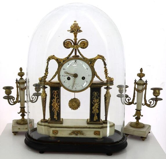 Louis XVI style mantel set in white alabaster, black marble and gilded bronze comprising a glass globe clock (H 45 cm) and blackened wood base (H 55 cm) and a pair of two-armed candelabra, H 29.5 cm. Enamelled dial signed "Collard à Paris". Thread...