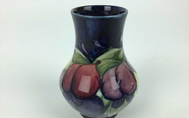 Moorcroft pottery vase decorated in the Wisteria pattern on blue ground, impressed marks and blue painted signature to base, 12.5cm high