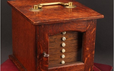 Numismatics - An Edwardian Arts and Crafts oak coin cabinet,...