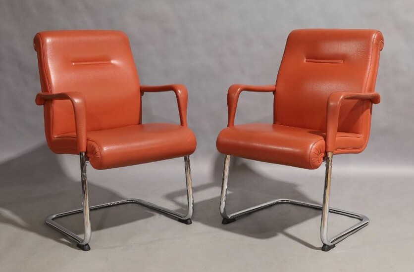 Poltrona Frau, a pair of cantilever armchairs, circa 1990, with vermillion leather seats on chromed metal supports, manufacturers label to underside, and mark stamped to leather, 92cm high, 61cm wide (2)