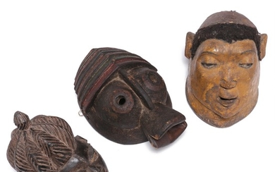Three masks of carved patinated wood, one clad with hair and red, white and yellow pigment. Yoruba, Makonde and Mumuye style. H. 26–34 cm. (3)