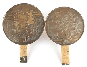 Two Japanese bronze hand mirrors cast with cranes, flowers a...