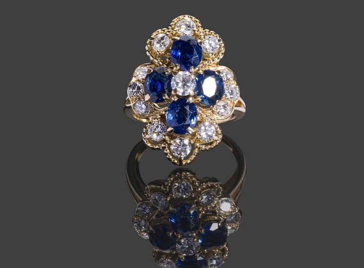 Yellow gold ring with 750 thousandths of a chantourné motif set with four oval sapphires and thirteen brilliants in a 10.7 g pearl setting, size 57 - Diamonds: 1 x 0.20 carat, 6 x 0.10 carat and 6 x 0.04 carat - Sapphires.