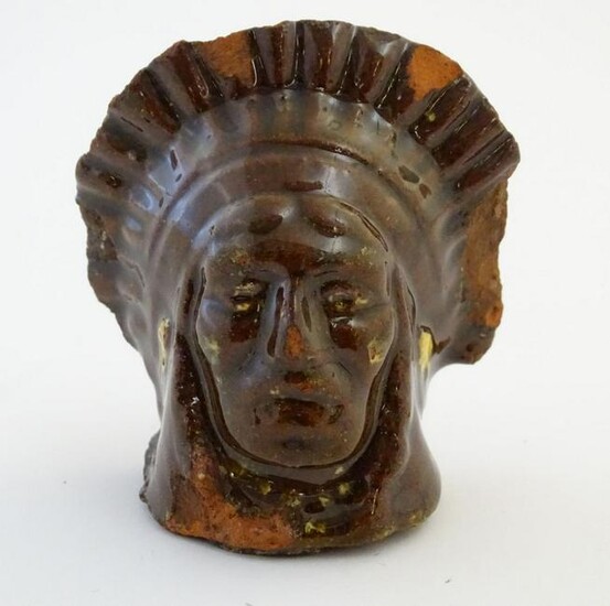 A 19thC treacle and slip glazed terracotta window stop
