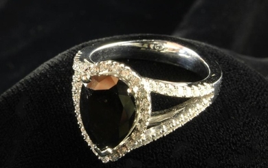 A 2.62 Carat Fancy Black Diamond Ring; The pear cut stone surrounded by round brilliant cut white di