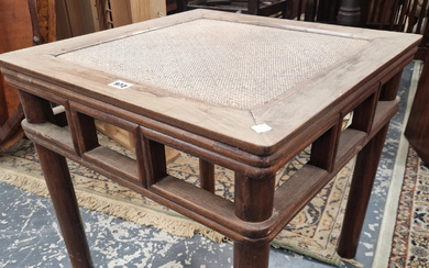 A CHINESE HARDWOOD COFFEE TABLE, THE CANE INSET TOP ABOVE AN OPEN WORK APRON AND FOUR CYLINDRICAL