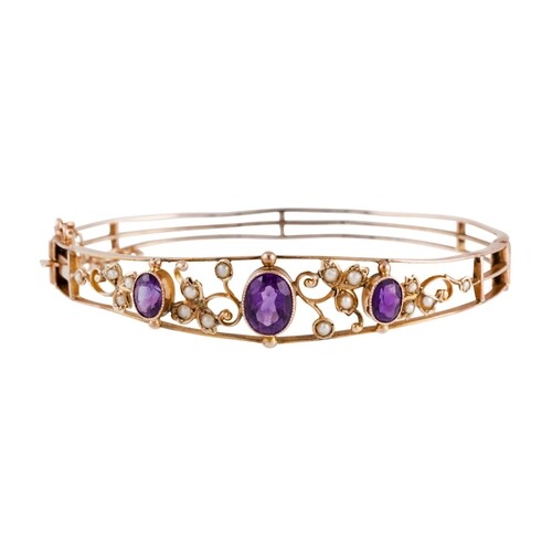A VICTORIAN AMETHYST AND SEED PEARL BANGLE, mounted in yello...