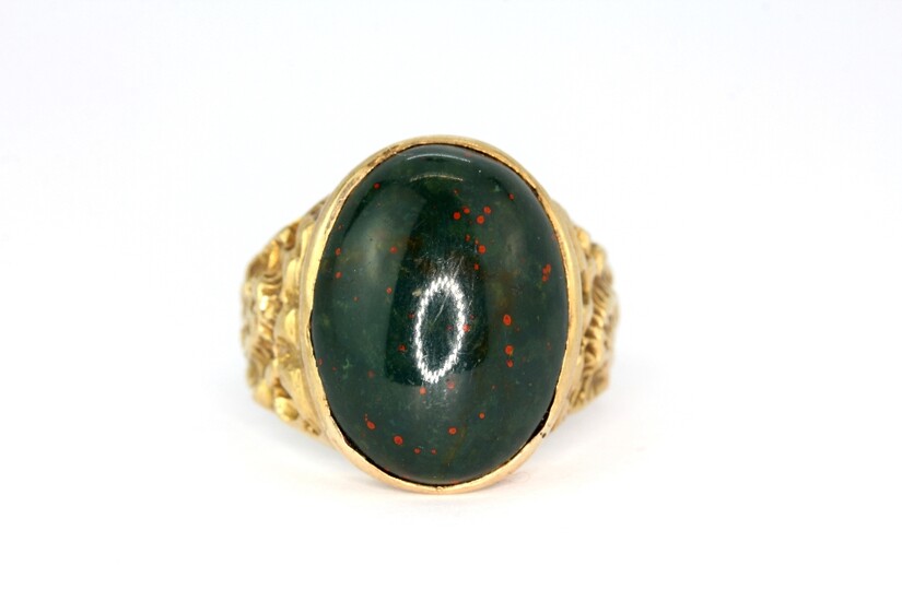 A hallmarked 9ct yellow gold ring set with a large cabochon oval cut bloodstone, (S.5).