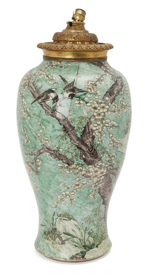 A large Chinese famille verte 'phoenix tail vase', yenyen, Kangxi period, decorated in enamels with magpies in the branches of a flowering prunus tree on a green ground, the heavily potted vase standing on a stepped foot with a waisted lower body...