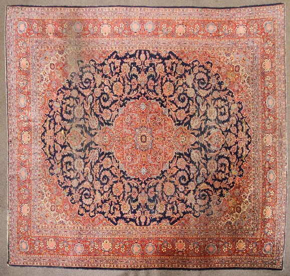 A large Persian silk/wool red ground rug with central floral panel and three floral borders