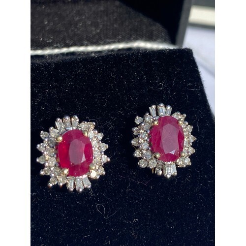 A pair of ruby and diamond earrings, of cluster design, set ...