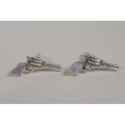 A pair of sterling silver cufflinks in the form of pistols w...