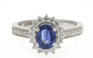 NOT SOLD. A sapphire and diamond ring set with an oval-cut sapphire encircled by numerous...