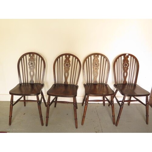 A set of four early 20th century wheelback dining chairs in ...