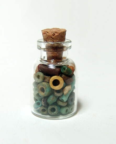 A small bottle filled with Egyptian faience beads