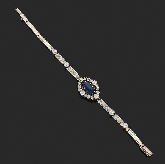 ARTICULATED BRACELET in 750-thousandths white gold, the elongated links, some adorned with round, antique cut diamonds, retaining in the centre a motif set with a cabochon blue synthetic stone in a surround of round, cushion-cut diamonds. Length. 16.5...