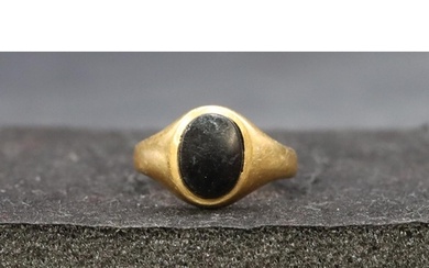 An 18ct gold oval signet ring set with black stone, Size J, ...