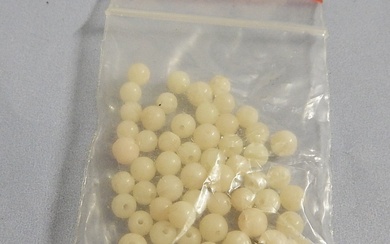 Bag with loose, white beads, together
