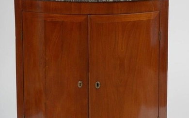 Curved Directoire style mahogany veneered corner opening with a door and topped with a black grey veined marble shelf. Period: late 18th century. (One corner of the marble restored). Dim.:+/-72x84x51,5cm.