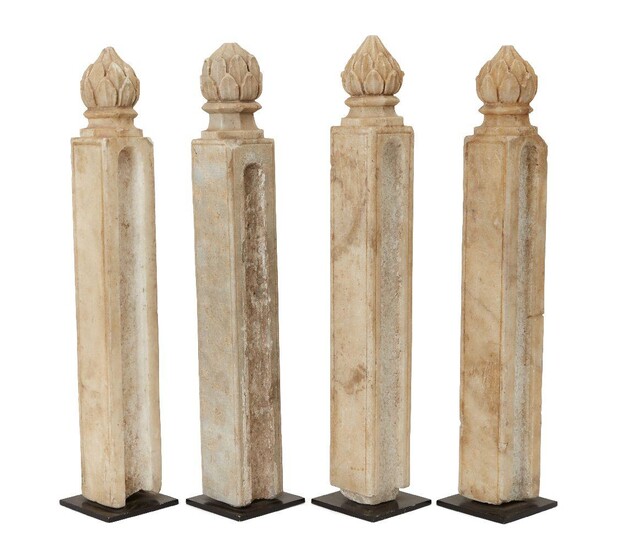 Four Mughal columnar shaped carved marble posts with finials in the shape of a closed lotus bud, India, period of Muhammad Shah, circa 1740, the front and back of each post plain with a single incised line forming a frame, carved to either side...