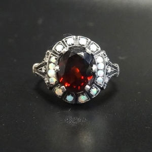 GARNET, OPAL AND DIAMOND CLUSTER RING the central oval cut g...