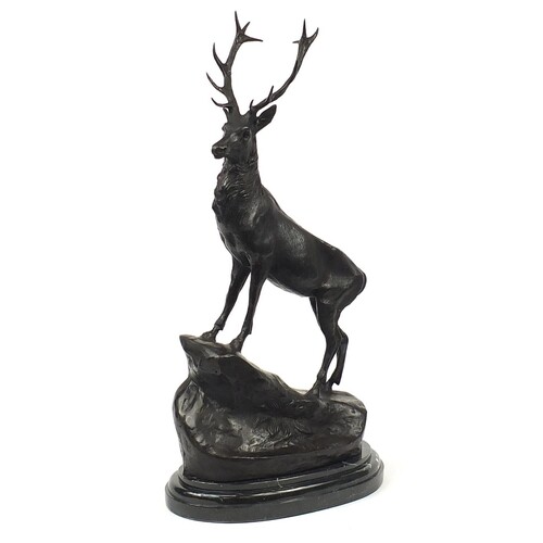 Large patinated bronze stag raised on a shaped marble base, ...
