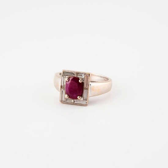 Rhodium-plated yellow gold (750) ring with a rectangular bezel centered on an oval (treated) faceted ruby in claw setting in a ring of baguette-cut diamonds in rail setting.