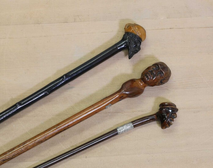 Three walking sticks with carved head handles