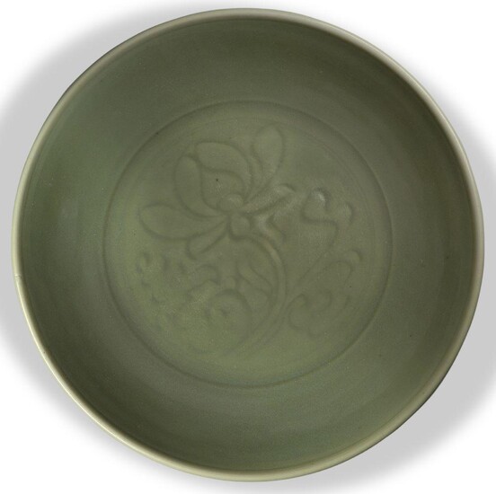 A Chinese Longquan celadon 'lotus' charger, Ming dynasty, the interior decorated with a large incised lotus blossom issuing from a leafy stem, 36.5cm diameter