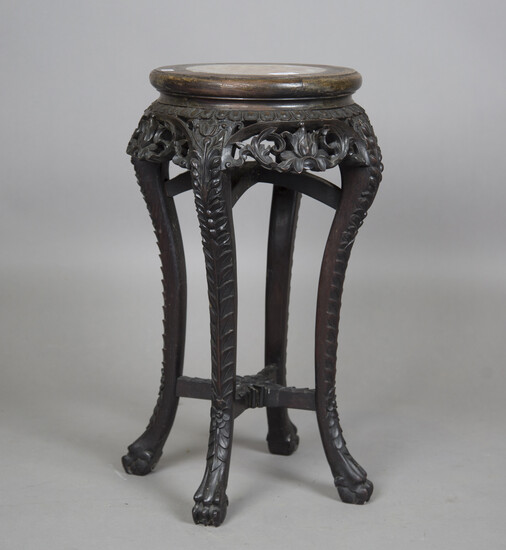 A Chinese carved hardwood stand, late 19th/early 20th century, the circular top inset with a rouge m