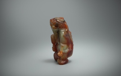 A Chinese mottled jade model of a seated mythical beast