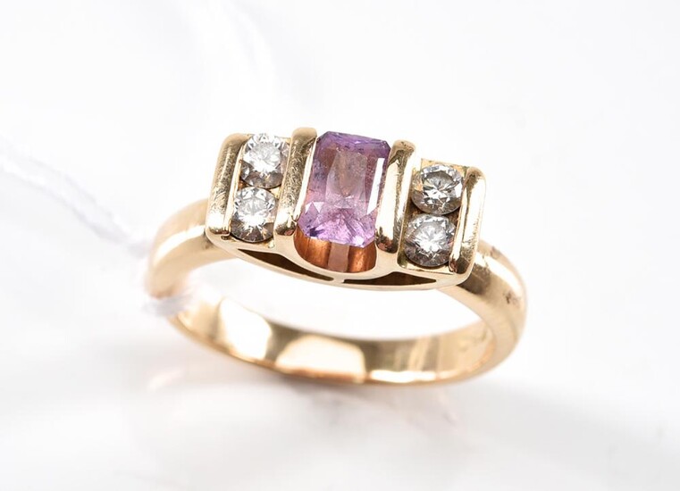 A PINK SAPPHIRE AND DIAMOND RING - Centrally set with a sapphire flanked by four diamonds in 18ct gold, size K, 7.3gms.