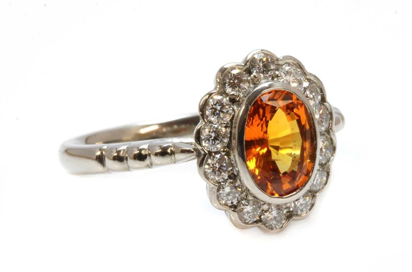 An 18ct white gold orange sapphire and diamond oval cluster ring