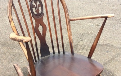 An Ercol elm & beech rocking chair with arched spindled...