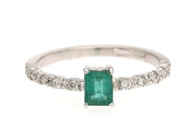 An emerald and diamond ring set with an emerald weighing app. 0.41 ct. flanked by ten diamonds, mounted in 18k white gold. Size 52.5.