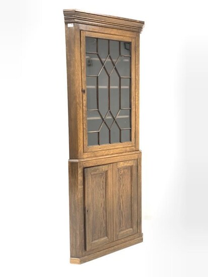 Early 19th century oak floor standing corner cupboard, projecting...