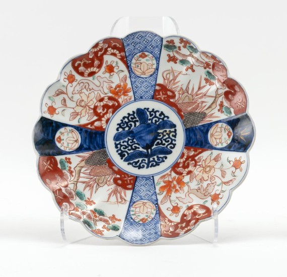 JAPANESE IMARI DISH In sixteen-petal flower form, with a lotus center and a shishi crane and flower border. Diameter 10.3".