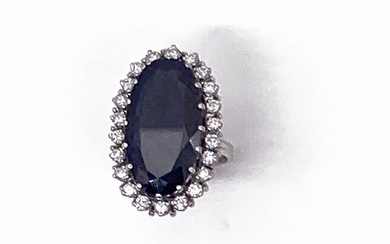 MARQUISE RING in platinum, adorned with a large sapphire of approximately 13.5 carats in a setting of 22 brilliant-cut diamonds. Gross weight: 11.5 g TDD: 56 A sapphire and diamonds platinum ring