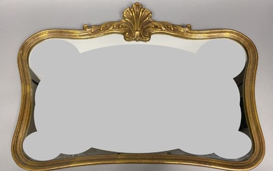 Miroir en bois et composition doré à bord chantourné à décor de coquille sculpt…