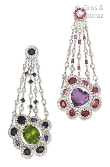 Pair of " Fleur " earrings in white gold, composed of alternating chains of brilliant-cut diamonds and calibrated sapphires, retaining the floral motifs set for one with a peridot in a ring of brilliant-cut diamonds and facetted sapphires and for the...