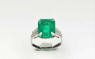 Platinum ring (850/oo), centered on a rectangular cut-faceted emerald calibrating...